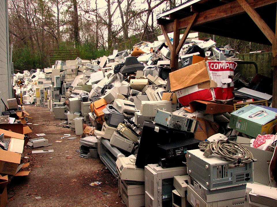 Pile of discarded electronic waste including old computers and monitors
